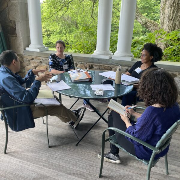 Four people around table having meeting