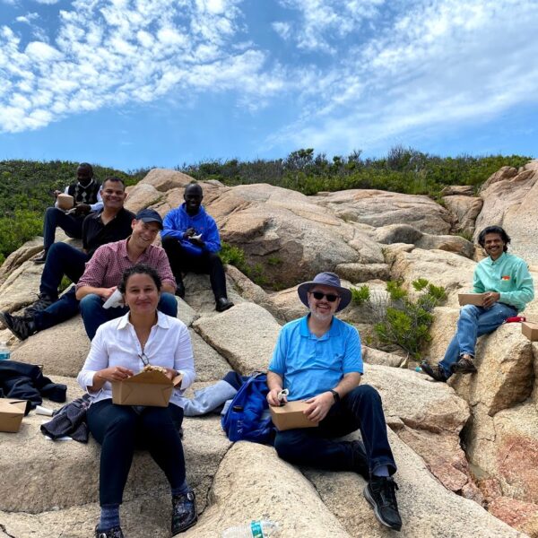 Group photo of Institute Participants sitting outside on rocks