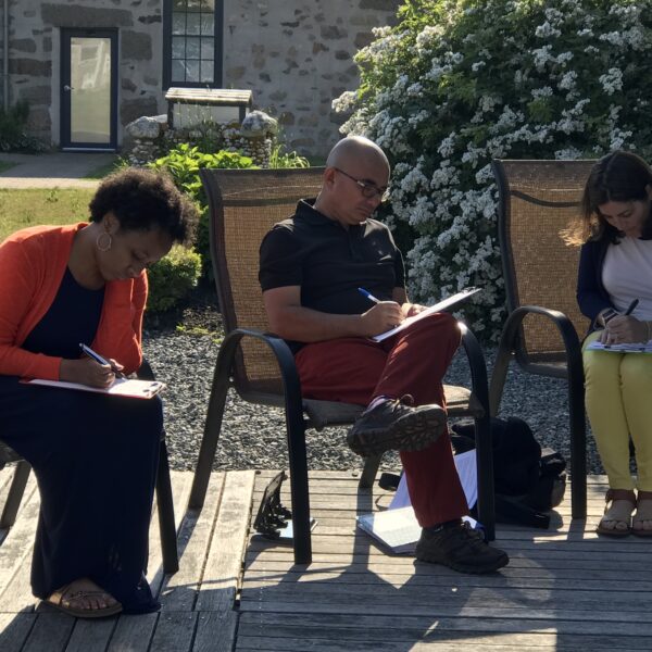 Three Institute Participants work outside on chairs